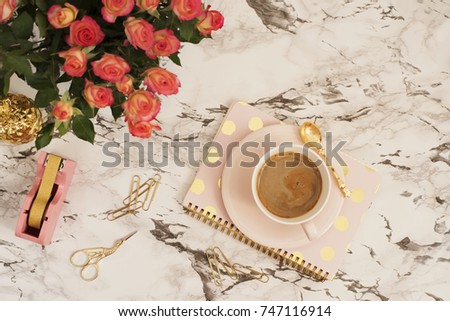 Feminine workplace concept. Freelance workspace in flat lay style with coffee, flowers, golden pineapple, notebook and paper clips on white marble background. Top view, bright, pink and gold