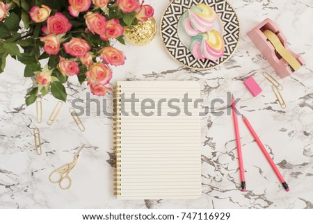 Feminine workplace concept. Freelance fashion comfortable femininity workspace in flat lay style with flowers, golden pineapple, notebook on white marble background. Top view, bright, pink and gold