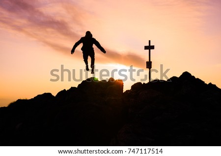 Athlete run on the top of the hill in mountains. Happy active photo. Silhouette of sport active man
