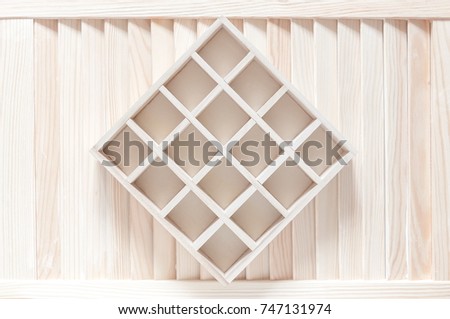 Wooden box with cells on a white wooden background. Empty shelves in a wooden rack
