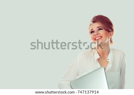 Happy and successful. Smiling laughing girl holding white laptop looking up. One single person isolated light green white wall background. Business clothes Positive emotion face expression. Copy space