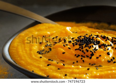 Fresh pumpkin soup in a bowl on a dark background