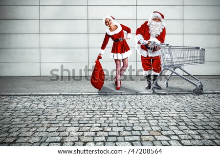 A photo of people making a Christmas shopping. The wall of the shop and the pavement in neutral gray.