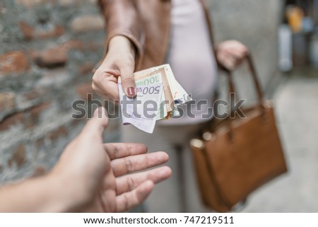 Woman giving money to a man. Woman paying money. Hands close up. Venality, bribe, corruption concept. Hand giving money. Corrupted business woman offering money for bribe