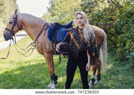 Young attractive blonde lady with a horse. Sunny day, happy moment, friendship. Autumn concept