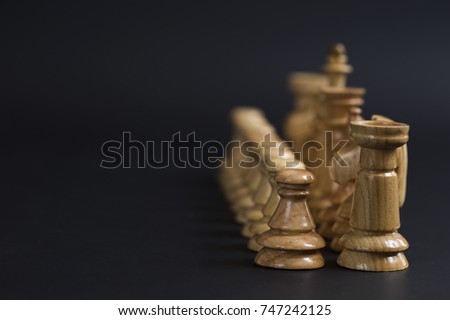 Chess. Figures on the position. Confrontation. Strategic game. Wooden Chess tournament on a black background.