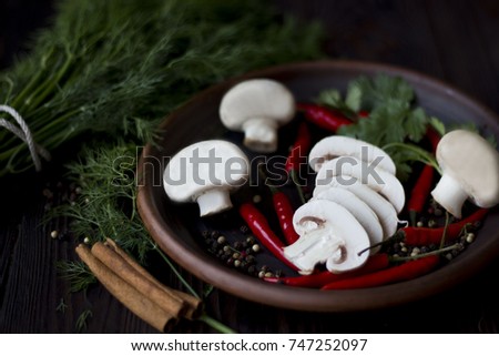 mushrooms with spices, cinnamon, red pepper on a plate on wooden background, concept food