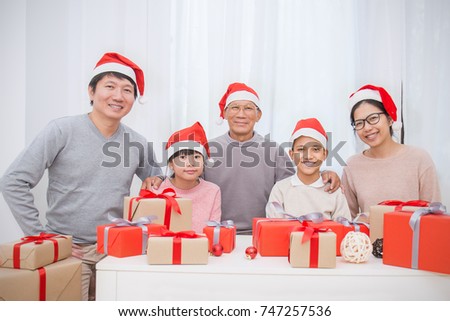 Portrait of asian family in sofa giving presents for Christmas, asian family celebrate Christmas boxing day open the gift