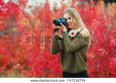 Girl photographer covering her face with the camera.