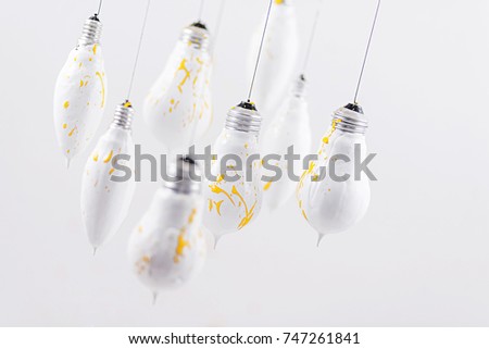 White light bulbs with yellow spray on a white background. Gray and yellow - mod colors of 2021.