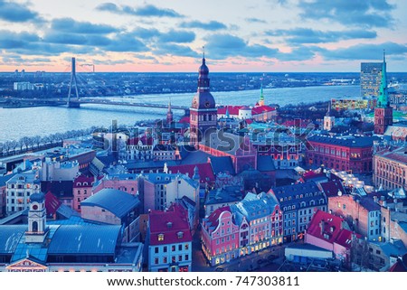 Panoramic view on Riga Old Town with Dome Cathedral and Daugava River at sunset in winter
