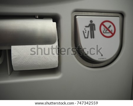 Airplane toilet tissues paper and no smoking sign and littering trash can sign