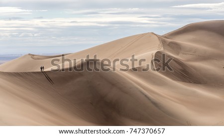 Couple hiking at Great Sand Dunes National Park, Colorado Royalty-Free Stock Photo #747370657