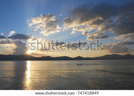 Sky at sunset and a boat in the middle of the Ranong Sea, Thailand.