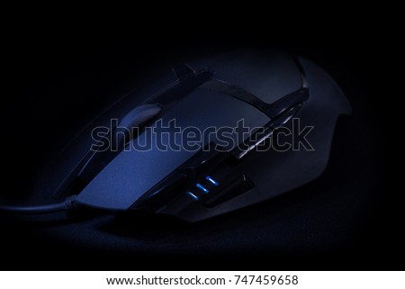 Sleek and cool modern black gaming mouse over a dark background.