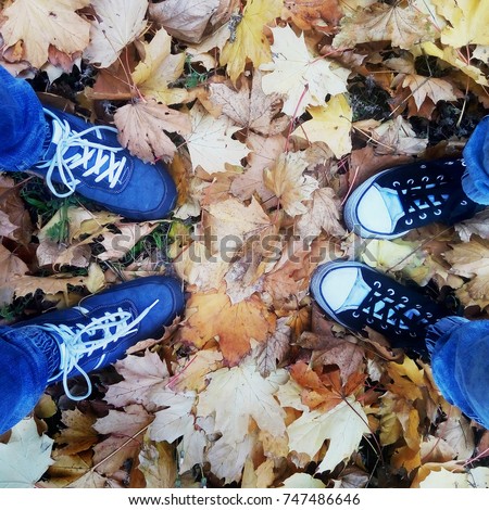 Boots on the background of yellow autumn leaves men and women.