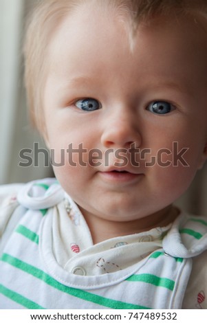 Nice portrait of Beautiful happy healthy cheerful adorable plump newborn baby boy dressed in green stripes pattern clothes