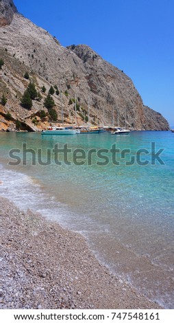 Photo from tropical rocky seascape with turquoise and sapphire clear waters and docked boats                             