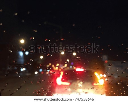 Dark background, Raindrops on the windshield, street lights at night on a rainy day.