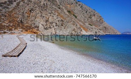 Photo from iconic beach of Agios Georgios with turquoise clear waters, Symi island, Dodecanese, Greece            
