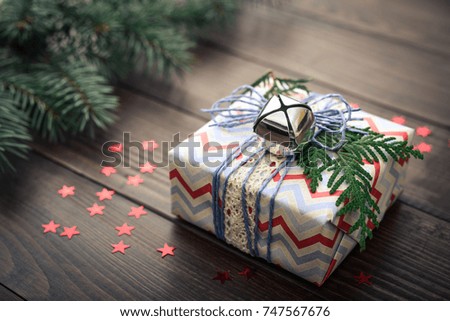 Christmas gift with fir tree twig on wooden background
