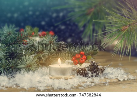Christmas background with spruce and a burning candle.