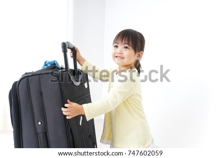 Child carrying a suitcase
