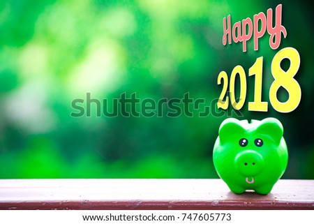 Pork piggy bank with number 2018 on tree blurry backgorund for happy new year image. And welcome new year photo.