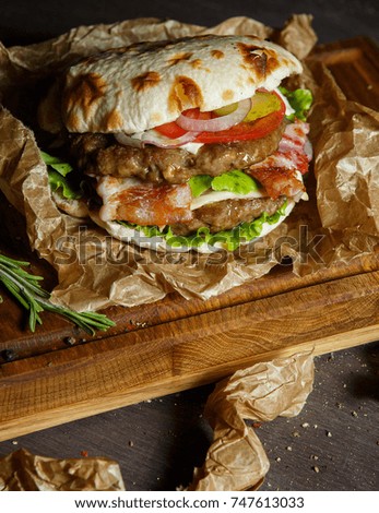 Burger with meat on a wooden board