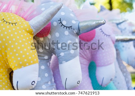 Shop showcase of the soft toy unicorn - pillows, lined up in a row