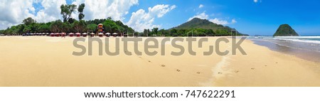 Panoramic view of Red island beach in Banyuwangi regency in Indonesia. Family walking along sea surf by empty of people endless sand beach. Java popular travel destination. Summer holiday background.
