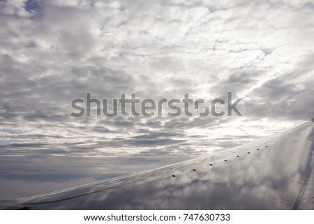 sky-scape with clouds and an airplane wing