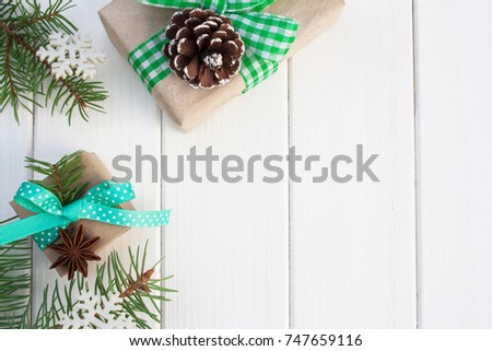 Christmas gift boxes and Christmas tree branches on a white wooden table