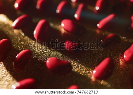 Red beans lie on a gold background in the defocus