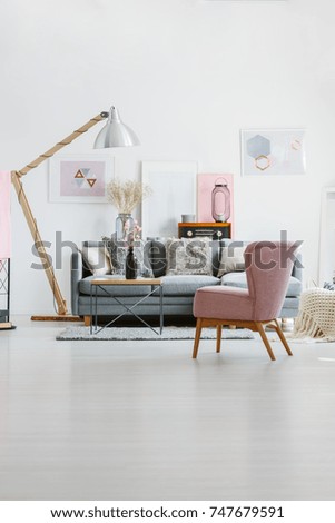 Vertical view of pastel retro room with pink armchair, flowers and wooden lamp