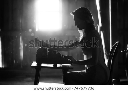 Silhouette of a beautiful girl in a dress on the background of a window in an old house
