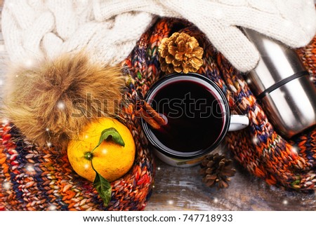 Cold weather walking set: warm clothes, hot mulled wine and thermos flask on wooden background. Healthy lifestyle concept
