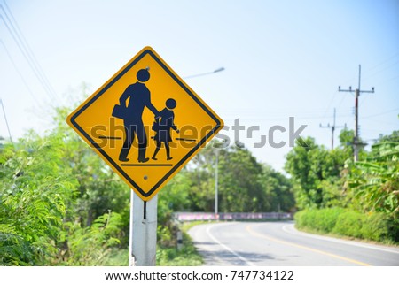 Beware of people or children crossing the street in school zone, Road symbol signs and traffic symbols for roadway, Yellow board with reflection and concrete post