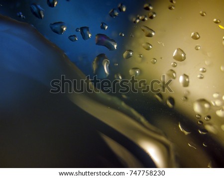 Drops of water on the glass, light from different sides, faded glass with a background