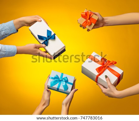 The closeup picture of man and woman's hands with gift box