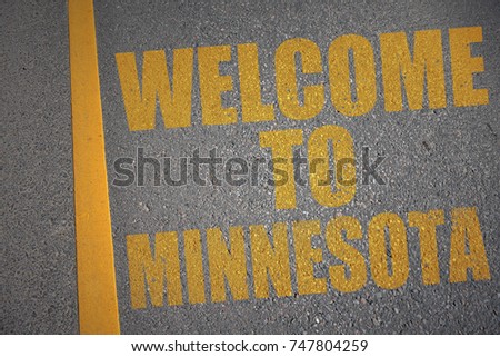 asphalt road with text welcome to minnesota near yellow line. concept