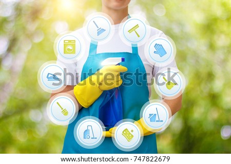 Cleaning lady provides cleaning services on blurred background. Royalty-Free Stock Photo #747822679