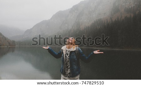 Attractive female hiker enjoys the view of lake Montriond in French Alps on a rainy day