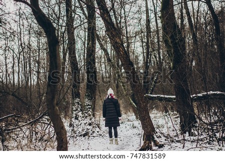 stylish hipster traveler girl with old photo camera exploring in snowy woods in winter. happy woman walking in cold forest. space for text. atmospheric moment. wanderlust