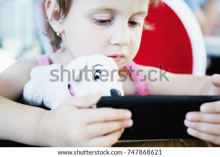 Social Media addiction. Little baby girl  holding phone (psychological problems, media mania, education)