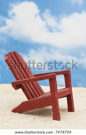 Wooden chair on sand with blue sky