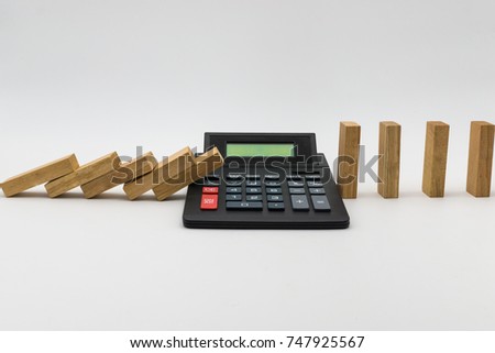 calculatorstopping a line of dominoes from falling. concept image