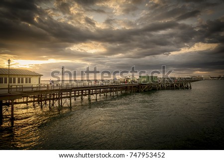 The sun setting behind the longest pleasure pier in the world, the Southend Pier in the UK, casting  a dramatic and striking light over the area.