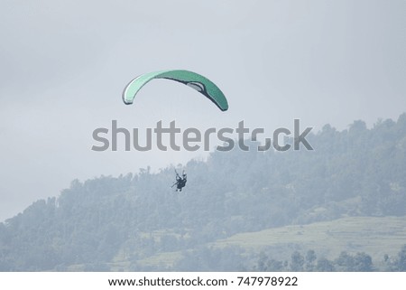 Paraglider Flying high above the hills 
