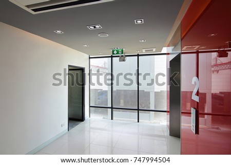 Elevator on second floor and emergency exit of the building with fire exit sign